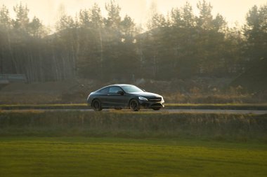 Boş yolda yüksek performanslı siyah bir araba.