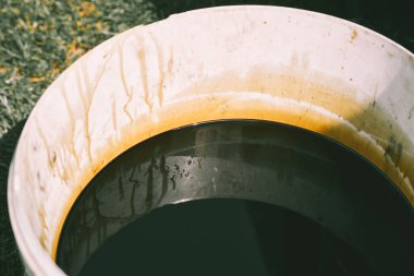 Atölye kovasında koyu renk motor yağı atığı