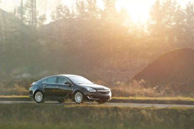 Zarif siyah araba açık yolda hız yapıyor.