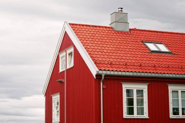 Norveç fiyortlarının yanındaki sonbahar ormanında kırmızı kulübe