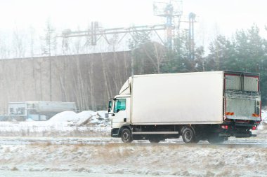 Karlı yolda büyük beyaz bir kamyon.