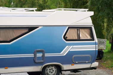 Doğada park etmiş mavi bir karavan.