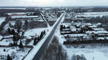 Kırsal kış yolu karlı tarlalarla çevrili.