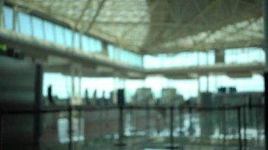 Bulanık bir havaalanı terminalinde yürüyen yolcular