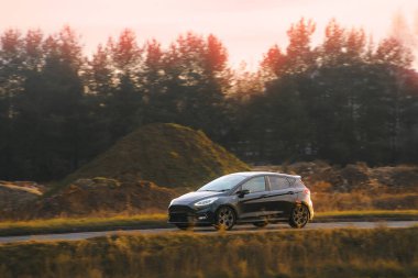 Manzaralı kırsal bir yolda araba sürüyor.