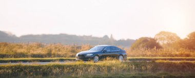Parlak modern sedan manzaralı kırsal yolda