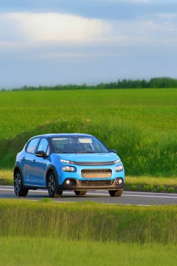 Manzaralı bir otoyolda hızlı giden bir SUV.