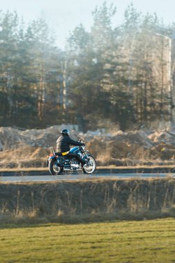 Açık arazide motosiklet süren bir adam.