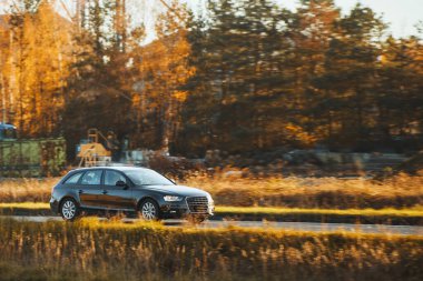 Kırsal yolda siyah bir araba sürüyordu.