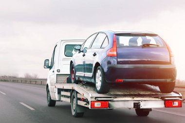 Çürük tamponlu araba düz yolda çekiliyor.