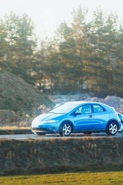 Kırsal yolda elektrikli SUV sürüyor.