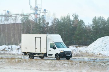 Karlı bir yolda kamyon sürüyor.