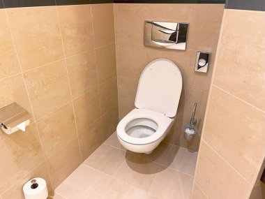 Duvara asılmış tuvalet ve fayansların olduğu minimalist banyo.