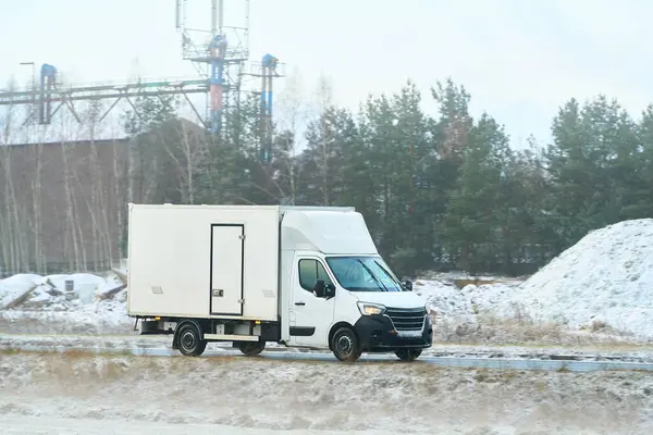 Karlı bir yolda kamyon sürüyor.