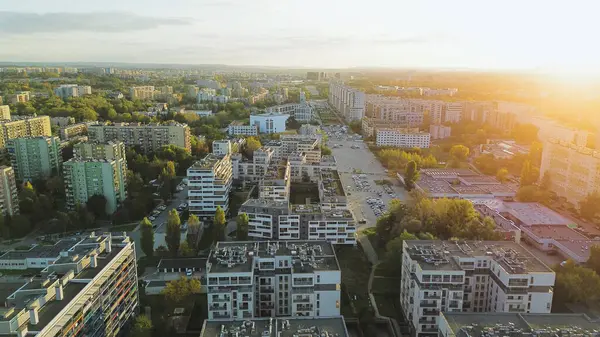 Güneşli bir akşamda şehrin apartman ve caddelerinin insansız hava aracı görüntüsü