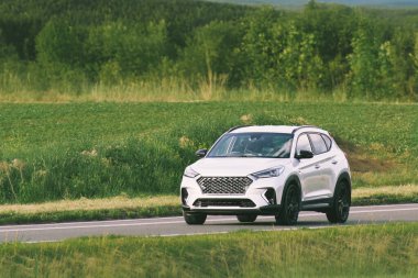 Crossover SUV açık kırsal yolda seyahat ediyor.