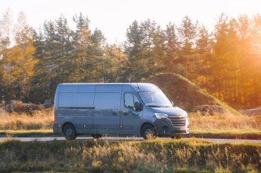 Çimen tarlasından geçen bir teslimat aracı.