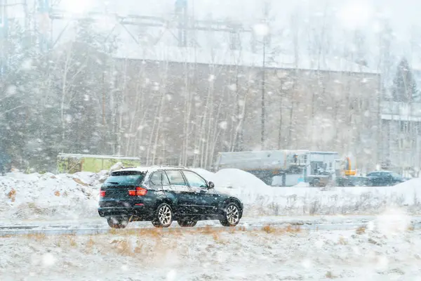 Karlı havada araba kullanan kompakt SUV