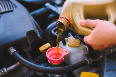 Araç motoruna yağ dökülüyor.
