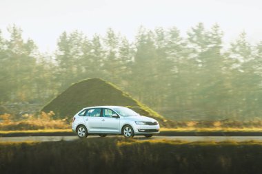 Modern hatchback arabası kırsal yolda seyahat ediyor.
