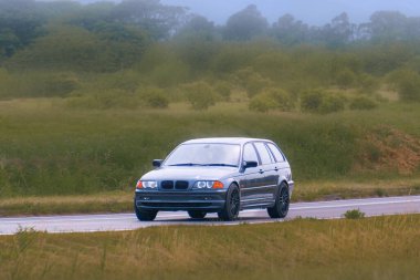 Yeşil arazide araba süren tutkulu klasik araba.