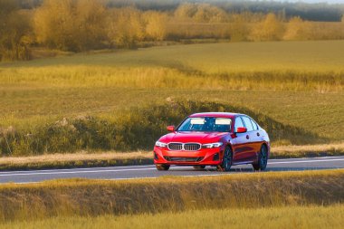 Manzaralı otoyolda giden özel sedan.