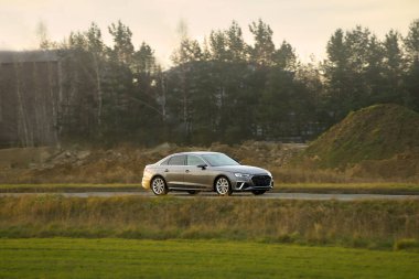 Şehir caddesinde lüks bir araç sürüyor.