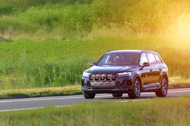 Dolambaçlı bir yolda lüks bir SUV araba.