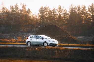 Modern hatchback arabası kırsal yolda seyahat ediyor.