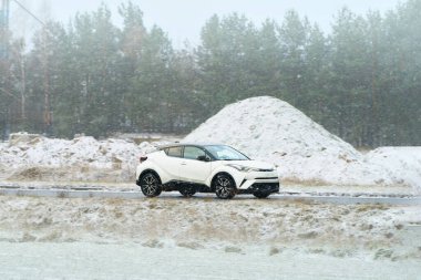 Kış manzarasında karda araba sürüyor.
