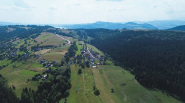 Yumuşak günbatımı ışığında yeşil tarlalar ve dağ sıraları
