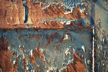 Paslı kapı detayı ve sıcak doğal ışık altında pul pul dökülen boya..