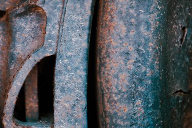 Eski tren vagonundaki paslanmış demir tekerleklerin makro görüntüsü.