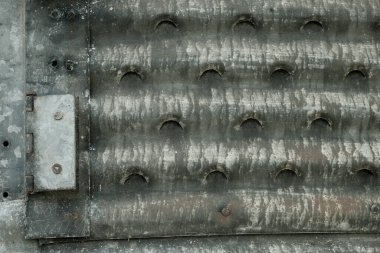 Paslanmış, galvanize metal yapıda parlak menteşeler.