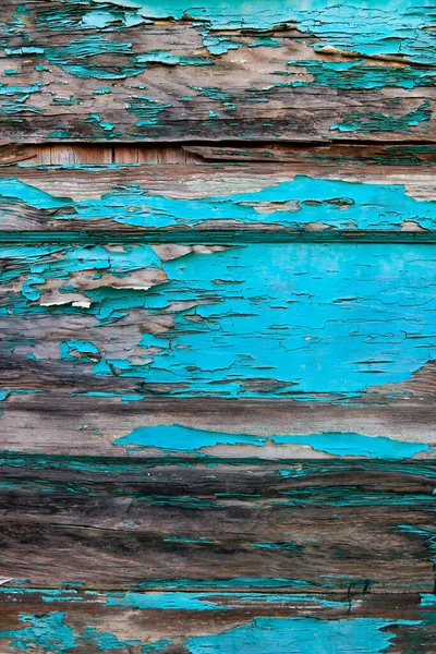 Peeling blue paint on wooden door panels