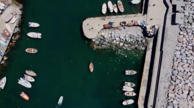 Camogli 'deki işlek limanda hareket eden kayaların ve teknelerin hava görüntüsü.
