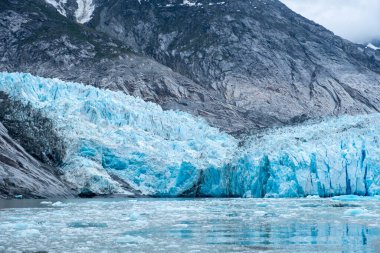 Topraklı, bulutlu ve yüzen buzlu buzullar.