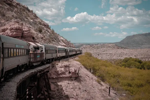 Clarkdale, Arizona, ABD - 16 Mayıs 2024: Turist treni mavi gökyüzünde açık hava bulutlarıyla Verde Vadisi 'nden geçiyor