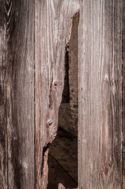 Çatlak ahşap kepenk eski tuğla duvarı ortaya çıkarıyor.