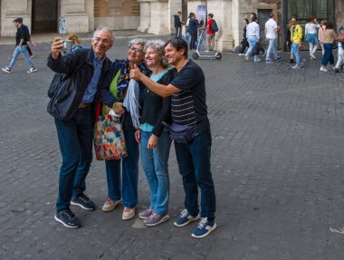 Roma, İtalya - 22 Ekim 2022 Piazza del Popolo Piazza del Popolo. Un gruppo di turisti si fa un selfie. Roma 'nın mimarisi ve manzarası.
