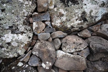 Dağların yakınındaki büyük kaya ya da kayaların yakınında. Büyük, renkli granitler. Güneş ışığında parlayan turuncu parçacıkların olduğu büyük gri taş yapıların ayrıntıları. Sert desenli kum taşları