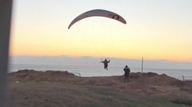 İsrail 'de paragliding ya da hang-sliding: 5 Ocak 2023, Netanya' da deniz kıyısında. Burası İsrail Ulusal Yolu 'nun geçtiği yer..