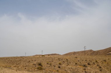 İsrail 'deki Negev Çölü' nde renkli kum ve bulutlu gökyüzü ile güzel kuru bir manzara. Yüksek çözünürlüklü.