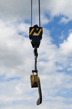 Vinç kancası, bulutların arkasında çelik halatlarla asılı duruyor. Yüksek kalite fotoğraf