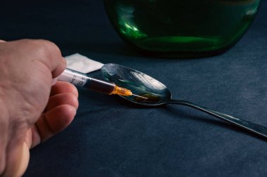 Uyuşturucu bağımlılığı konsepti. Şırınga kaşıkta hazırlanmış eroinle dolu. Karanlık arka plan. Yüksek kalite fotoğraf