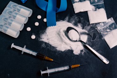 Uyuşturucu bağımlılığı konsepti. Enjeksiyon için hazırlanmış eroin, hap, ampul ve şırınga torbaları. Siyah arka plan. Yüksek kalite fotoğraf