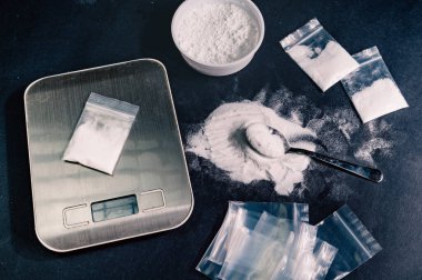 Eroin terazide tartılır ve yanında şırıngalar ve haplar bulunan küçük torbalarda paketlenir. Yüksek kalite fotoğraf