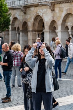 BUDAPEST, HUNGARY - 17 Eylül 2024: Turistler fotoğraf çekip Balıkçı Kalesi 'nin manzarasının tadını çıkarıyorlar. Yüksek kalite fotoğraf