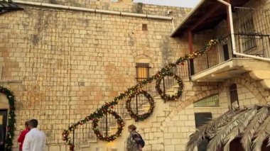 16 Aralık 2022. Miilya köyü, İsrail. Hristiyan Araplar. Kilisenin yakınındaki turistler. Gün boyunca 4K video görüntüsü
