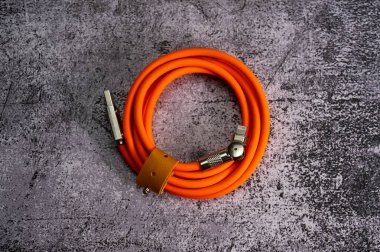 Mermer arka planda döner fişi olan turuncu USB tip-C kablo. iPhone şarj kablosu. Yüksek kalite fotoğraf